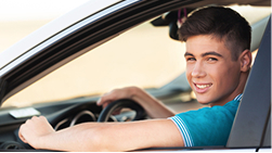 A young driver in a car, representing teen drivers coverage.